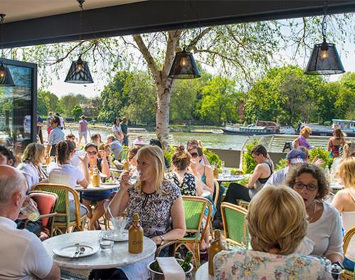 a group of people sitting at tables in a restaurant at Peaceful Home Berrylands Surbiton Surrey UK - Free Parkings in Surbiton