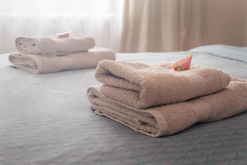 una pila de toallas sentadas encima de una cama en Heart of Mitau, en Jelgava