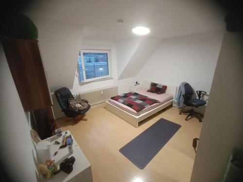 an overhead view of a bedroom with a bed and two chairs at Komm ins Mildewarme Dachgeschoß in Pforzheim