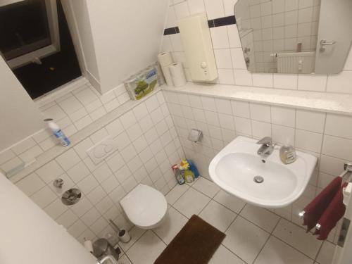 a white bathroom with a sink and a toilet at Komm ins Mildewarme Dachgeschoß in Pforzheim