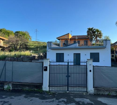 a white house with a gate in front of it at Damar in Giarre