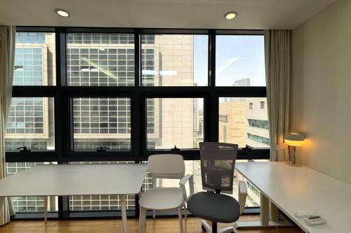 a white table and chairs in a room with windows at COEX VIP 15 New Open [2 Queen beds] in Seoul