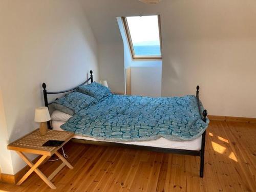 1 dormitorio con cama con edredón azul y mesa en M026 Teach Ban, en Westport