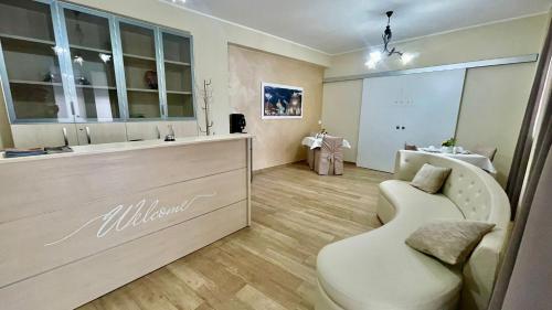 a salon with a white bench in a room at Oasi Perla Del Mare Rooms in Aci Castello