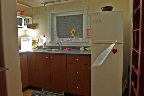 a kitchen with a white refrigerator and a sink at Thistle Dew Cottage in Ganges