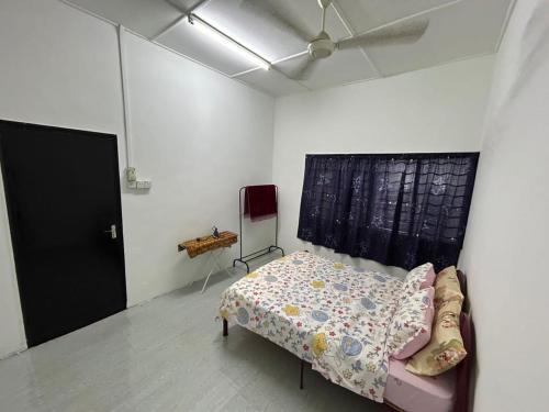 a bedroom with a bed and a ceiling fan at RumaDino Homestay in Melaka