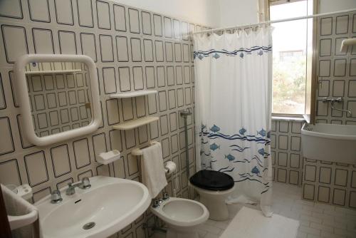 a bathroom with a sink and a toilet and a shower at Tre Fontane sul Mare in Tre Fontane