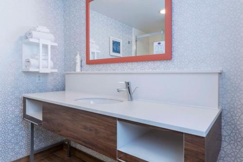a bathroom with a white sink and a mirror at Hampton Inn & Suites St. Louis-Chesterfield in Chesterfield