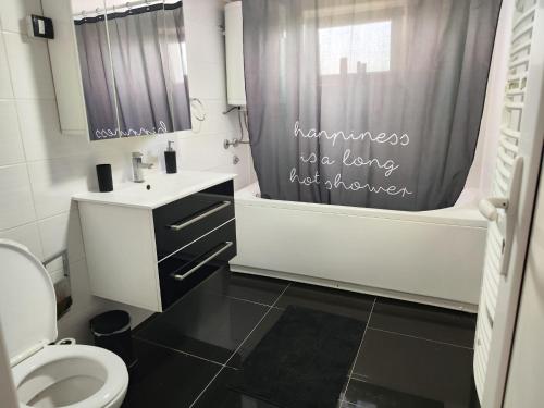 uma casa de banho com um WC e uma cortina de chuveiro em Nani Apartman - Banja Ždrelo em Malo Laole