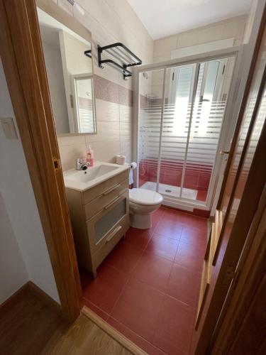 een badkamer met een wastafel, een toilet en een spiegel bij El caserío de la abuela in Cabezuela del Valle