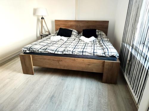 uma cama num quarto com piso em madeira em Nani Apartman - Banja Ždrelo em Malo Laole