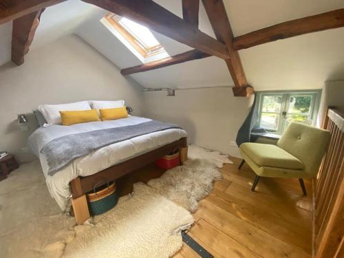 a bedroom with a bed and a chair and a rug at Cartmel Barn: Beckside Stables in Cartmel