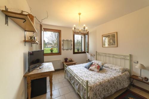 a bedroom with a bed and a tv and a table at Agriturismo Al Botteniga in Treviso