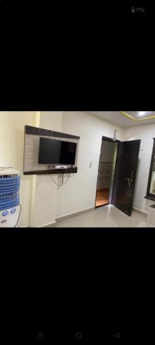 Pokój z telewizorem z płaskim ekranem na ścianie w obiekcie bombay rejency hotel w mieście Pachmarhi