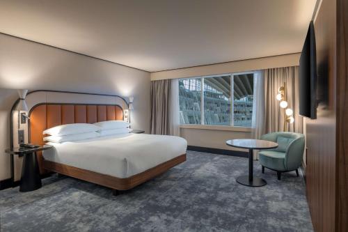 a hotel room with a bed and a chair and a window at Hilton Paris La Défense in Puteaux
