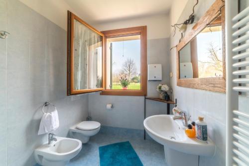 特雷維索的住宿－Agriturismo Al Botteniga，一间带两个盥洗盆、卫生间和窗户的浴室