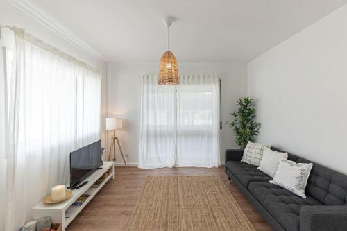 a living room with a couch and a tv at Casa da Ecovia in Arouca