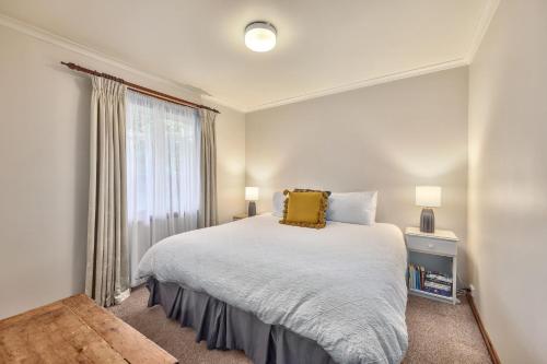 a bedroom with a bed with a yellow pillow on it at Jamieson Cottages - Cottage TWO - Sleeps 4 in Howqua