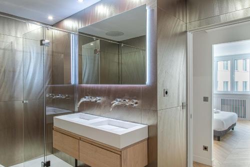 a bathroom with a sink and a mirror at Lavie Maison : A C & Eiffel Tower View in Paris
