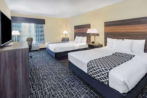 a hotel room with two beds and a flat screen tv at La Quinta by Wyndham Garland Harbor Point in Garland