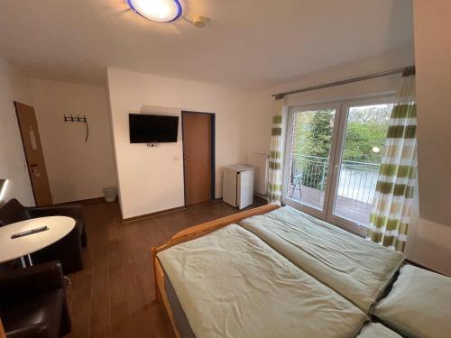 a bedroom with a bed and a large window at Pension Haus My in Norddeich