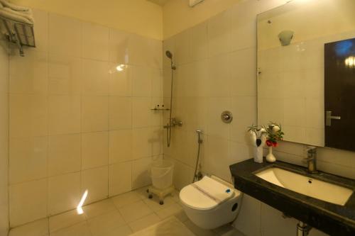 y baño con aseo, lavabo y espejo. en Hridey Retreat Resort, en Rāmnagar
