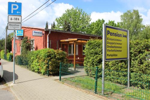 a sign on a fence in front of a building at Pension Schwalbenweg in Schönefeld