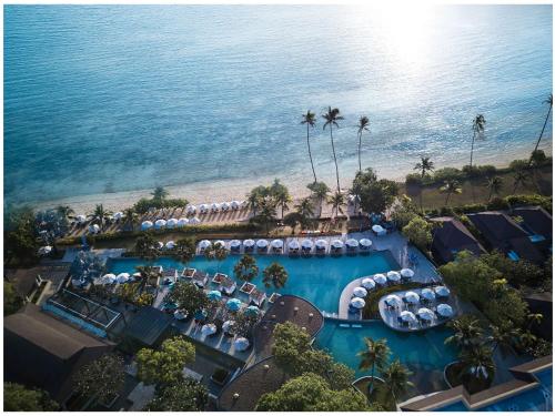 Pullman Phuket Panwa Beach Resort في شاطئ بنوا: اطلالة جوية على منتجع مع مسبح وشاطئ
