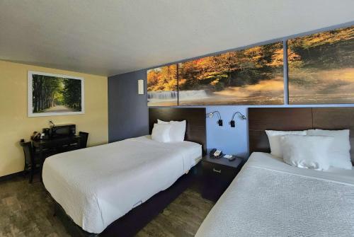 um quarto de hotel com duas camas e duas janelas em Days Inn by Wyndham New Orleans Pontchartrain em Nova Orleães