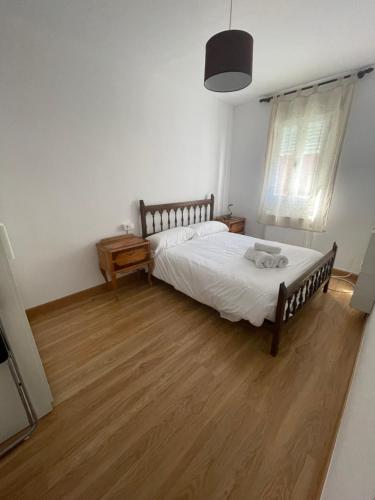 1 dormitorio con 1 cama y suelo de madera en El caserío de la abuela, en Cabezuela del Valle