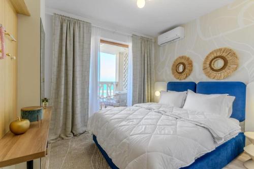 een slaapkamer met een blauw en wit bed en een raam bij Mare Vista Suite in Varna