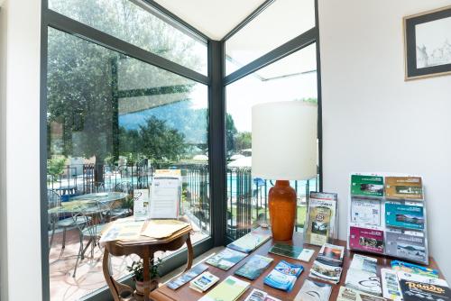 a room with a table with books and a lamp at Terra Umbra Hotel in Narni