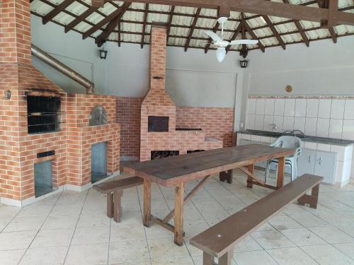 uma cozinha com uma mesa de madeira e um forno de tijolos em Casa de campo em São José dos Pinhais