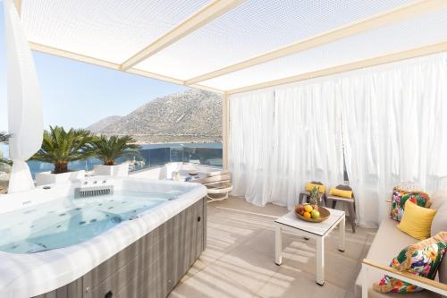 a large tub in a room with a view of the ocean at Villa Iris, beachfront, with jacuzzi, up to 9 guests, Mpali beach, Rethymno! in Balíon