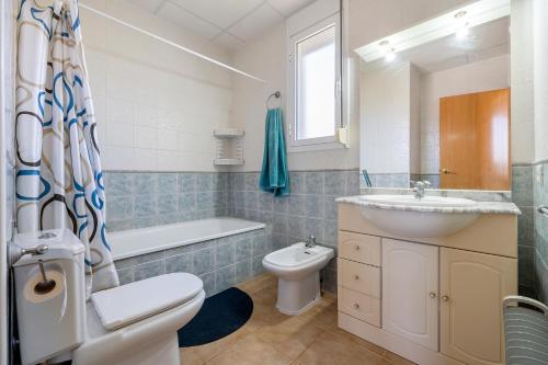 a bathroom with a sink and a toilet and a bath tub at Villa Alpamar in Les tres Cales