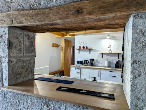 uma cozinha com armários brancos e um balcão com um lavatório em Charmante maison 6 pers, proche Loire à vélo em Suèvres
