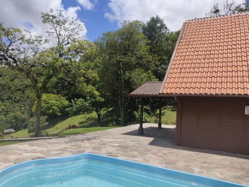uma casa com piscina ao lado de um edifício em Casa de campo em São José dos Pinhais