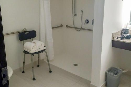 a bathroom with a shower with a chair and towels at Comfort Inn & Suites in Tunkhannock
