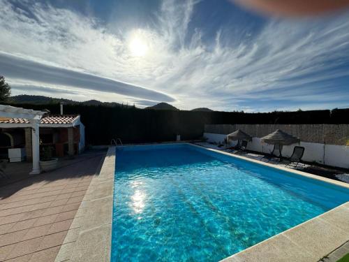 uma grande piscina azul em cima de uma casa em Villa Los Corralillos de Pepa em Padul