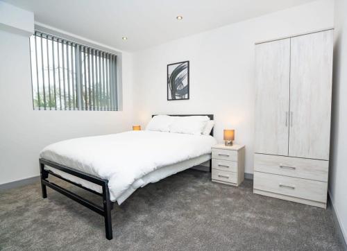 a white bedroom with a bed and a dresser at Bright and Modern 1 Bed Apartment in Redditch in Redditch