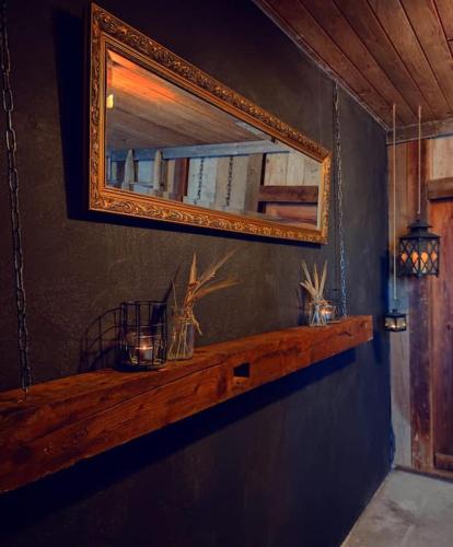 a mirror on a blue wall with a wooden shelf at Ferienhaus Bergträumli Keine Zufahrt in Gommiswald
