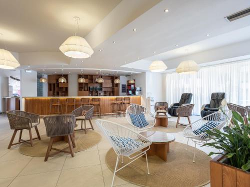 a waiting room with chairs and tables and a counter at Caldera Beach in Plataniás