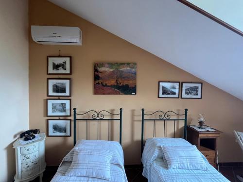 um quarto com duas camas e quadros na parede em Bed & Breakfast La Costa em Cassino