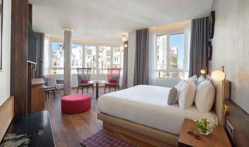 a hotel room with a bed and a living room at Hyatt Centric Gran Via Madrid in Madrid