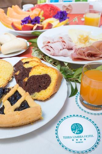 a table topped with plates of food and bread at Terra Umbra Hotel in Narni