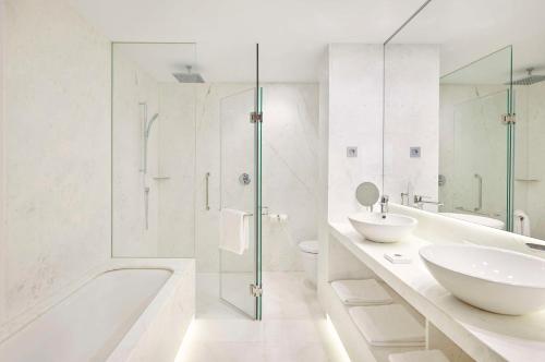 a white bathroom with a tub and a sink at Hyatt Centric Gran Via Madrid in Madrid