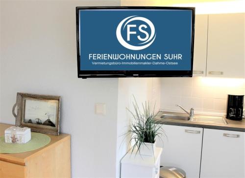 a flat screen tv hanging on a wall in a kitchen at Ostseehus Whg1a in Grömitz