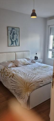 Ce lit se trouve dans une chambre blanche dotée d'un couvre-lit design. dans l'établissement Appartement Ajaccio, à Ajaccio