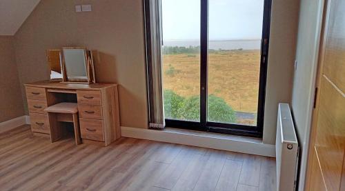 an empty room with a desk and a large window at M033 Achill Gatehouse By The Greenway in Westport