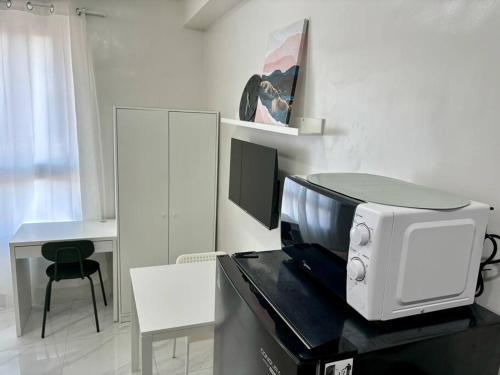 a microwave sitting on top of a counter in a kitchen at Casa Mira Guadalupe by Leera's Condo in Cebu City